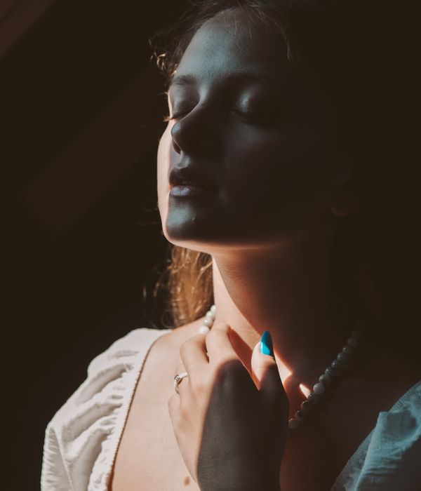 Serene woman enjoying morning light with eyes closed gently